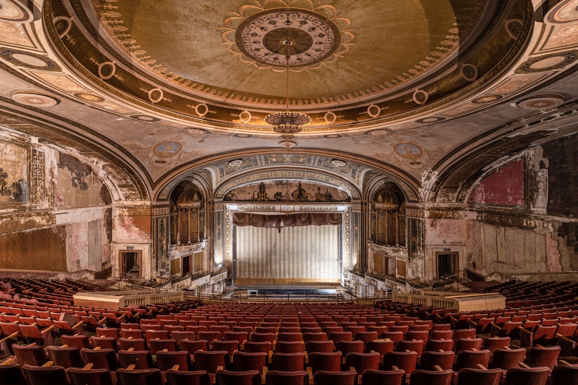 Abandoned theater, red seats under a painted dome